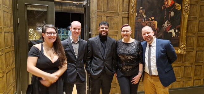 five people smiling at the camera